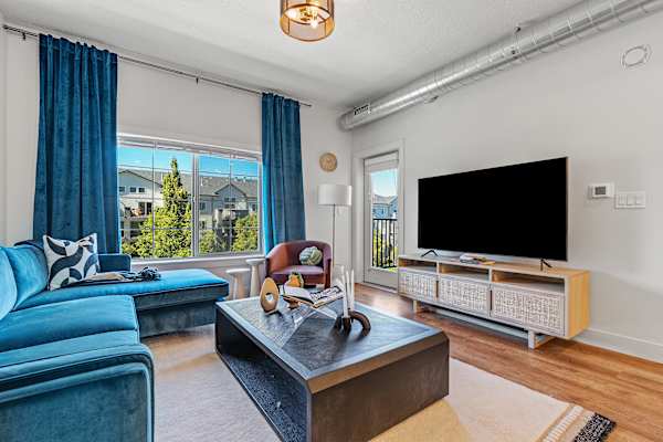 living room with a blue couch and TV at The Revival, Salt Lake City, UT